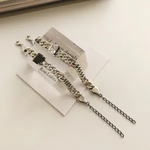 Vista detallada del pulsera de cadena gruesa de plata S925 con dijes de piedra en blanco y negro.