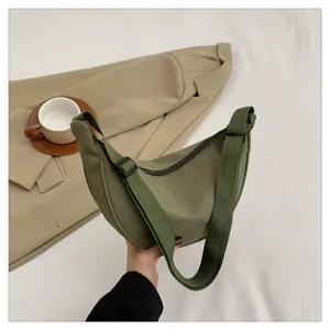 Green nylon dumpling shoulder bag detail shot showing adjustable strap and zipper closure style