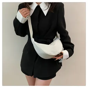 Detail view of white nylon crescent crossbody bag worn by model, casual daily style