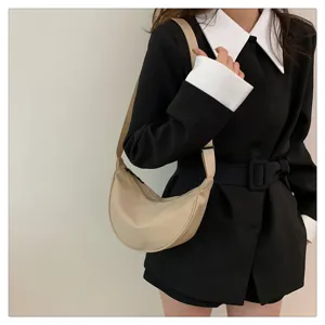 Close-up view of the casual beige nylon crescent shoulder bag, showing texture and strap details.