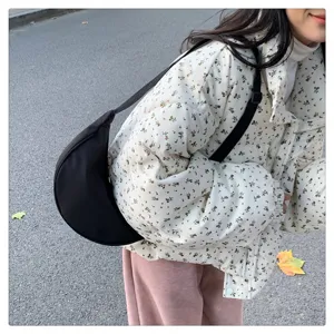 Detailed view of the black nylon crescent crossbody bag, featuring a casual sporty dumpling shape.