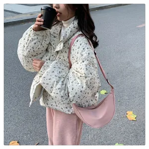Outdoor detail view of a lightweight pink nylon crescent crossbody dumpling bag for women's daily wear.