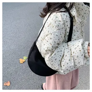 Detail shot of black nylon crescent crossbody bag, lightweight daily shoulder bag for women.
