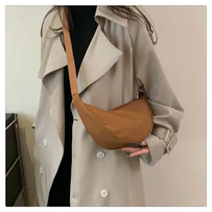 Detail view of the stylish nylon crescent shoulder bag worn in casual daily outfit.