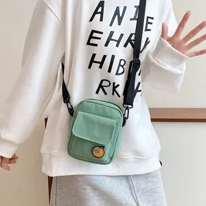 Cute canvas crossbody phone bag for girls, casual green small sling bag with orange patch.