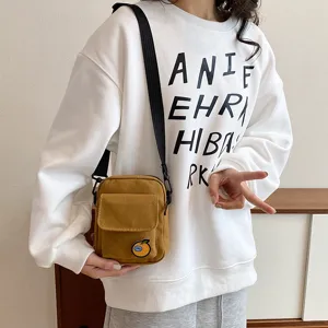 Cute canvas crossbody phone bag detail, yellow small shoulder bag with adjustable strap.