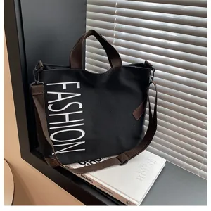 Casual black canvas tote bag with brown straps and bold fashion print for daily commute.