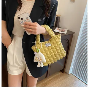 Vista detallada del bolso de mano plisado amarillo con colgante de peluche para mujeres.