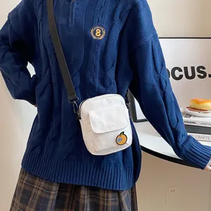 Detailed view of the sweet canvas crossbody bag featuring a cute patch and front pocket design.