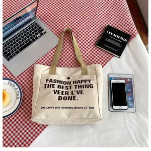 Canvas tote bag detail view showing large capacity and stylish front printed text in lifestyle scene.