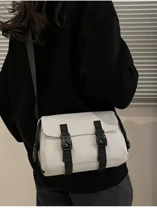 Vista de detalle del bolso de hombro táctico blanco con hebillas negras llevado por el modelo.