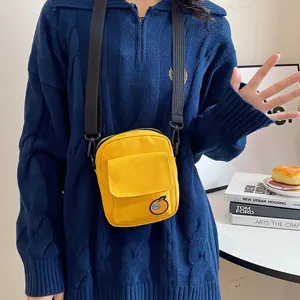 Cute canvas crossbody phone bag featuring a yellow front pocket and fun orange patch detail.