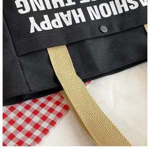 Canvas tote bag strap and fabric detail close-up, showing durable texture and stitching.