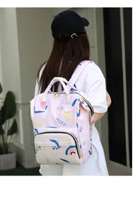 Detail view of a stylish pink diaper backpack with cute abstract patterns for modern moms.