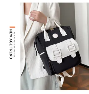 Stylish black and white backpack with front pocket and top handles for daily use.
