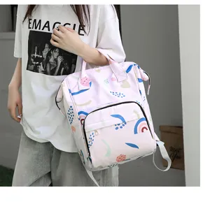 Detail view of the pink multi-function diaper backpack with cute abstract print and pockets.