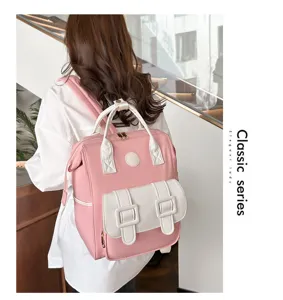 Detailed view of stylish pink backpack with white top handles and front dual buckle pocket.