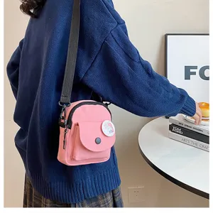 Vue detaillee d'un sac bandouliere en toile rose pour femmes et etudiantes au quotidien.