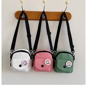 Vue détaillée de sacs bandoulière en toile décontractés en trois couleurs avec des badges.