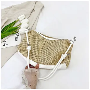 Detail view of woven straw shoulder bag with white PU leather trim and stylish knotted straps.