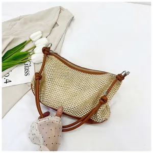 Detail shot of the vintage woven straw underarm bag, showing texture and brown leather strap.