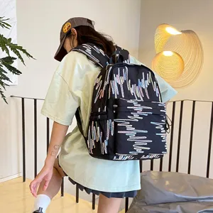 Nahaufnahme eines schwarzen Rucksacks mit bunter Wellenstickerei, modernes Design am Model.