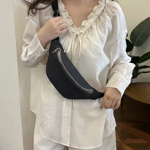 Stylish dark denim crossbody bag worn by a model, perfect for casual daily wear and travel.