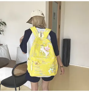 Sac à dos scolaire jaune décontracté avec motifs colorés et joli porte-clés étoile en peluche.