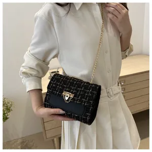 Λεπτομερης εικονα της μαυρης tweed mini τσαντας ωμου με χρυση αλυσιδα και κομψο κλειsιμο.