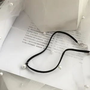 Elegante collana girocollo in velluto nero con dolci ciondoli di perle e chiusura in argento.