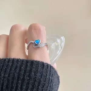 Gros plan sur la bague vague en argent 925 style vintage avec une jolie pierre coeur bleue.