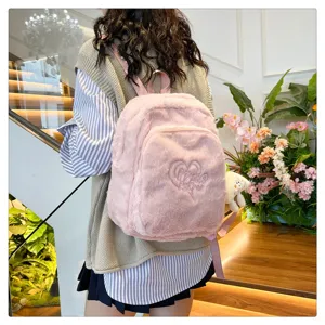 Close-up of pink plush backpack detail, soft faux fur texture with cute heart embroidery.