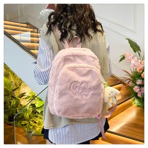 Detail view of pink plush backpack, featuring cute heart embroidery and soft furry texture.
