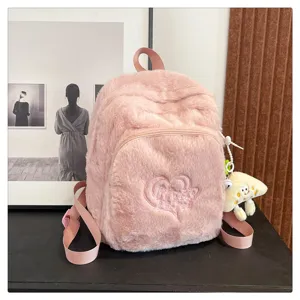 Close-up of pink plush backpack front pocket, heart embroidery and fluffy texture detail.