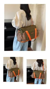 Detail view of large capacity travel duffel bag with contrast orange straps and side pockets.