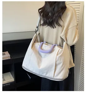 Large capacity travel duffel bag detail view, casual messenger style with purple handle.