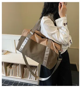 Detailansicht der stilvollen Reisetasche am Modell, mit Karo-Muster und Stoffkombination.