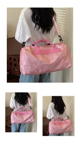 Vue détaillée du sac de voyage rose avec bandoulière, tissu durable et grand espace.