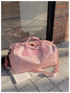 Détail de sac de voyage rose, bagage week-end léger avec bandoulière et design élégant.