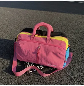 Vista dettagliata dell'elegante borsone da viaggio color-block con grande capacità e tracolla.