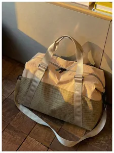 Detailansicht der stylischen Reisetasche mit strukturiertem karierten Stoff und stabilen Griffen.