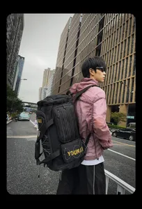 Detail shot of a trendy black multi-functional travel duffel bag with bold yellow lettering.