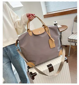 Detail view of large capacity travel duffel bag, waterproof nylon and leather trim for fitness.