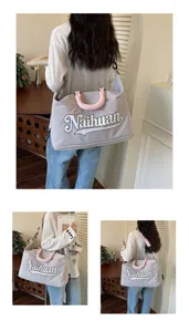 Vista detallada de bolsa de viaje de lona con letras, ideal para viajes cortos y gimnasio.