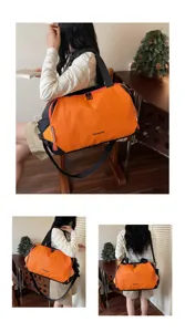 Detail view of the stylish orange and black travel duffel bag, showcasing its large capacity.