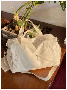 Detalle de la bolsa de viaje casual blanca que muestra textura y cremalleras.
