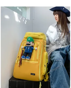 Large capacity yellow travel backpack with multiple compartments and cute plush toy pendant.