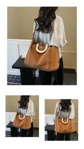 Large capacity travel duffel bag detail showing durable brown fabric and comfortable handle wrap.