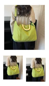Detailed view of the large capacity green travel duffle bag with comfortable yellow handles.