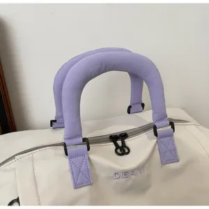 Detail view of the travel duffel bag showing reinforced purple handles and smooth zipper.